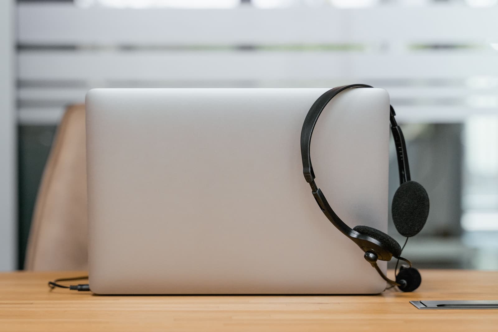 A laptop and a headset on a desk, ready for a video appointment.