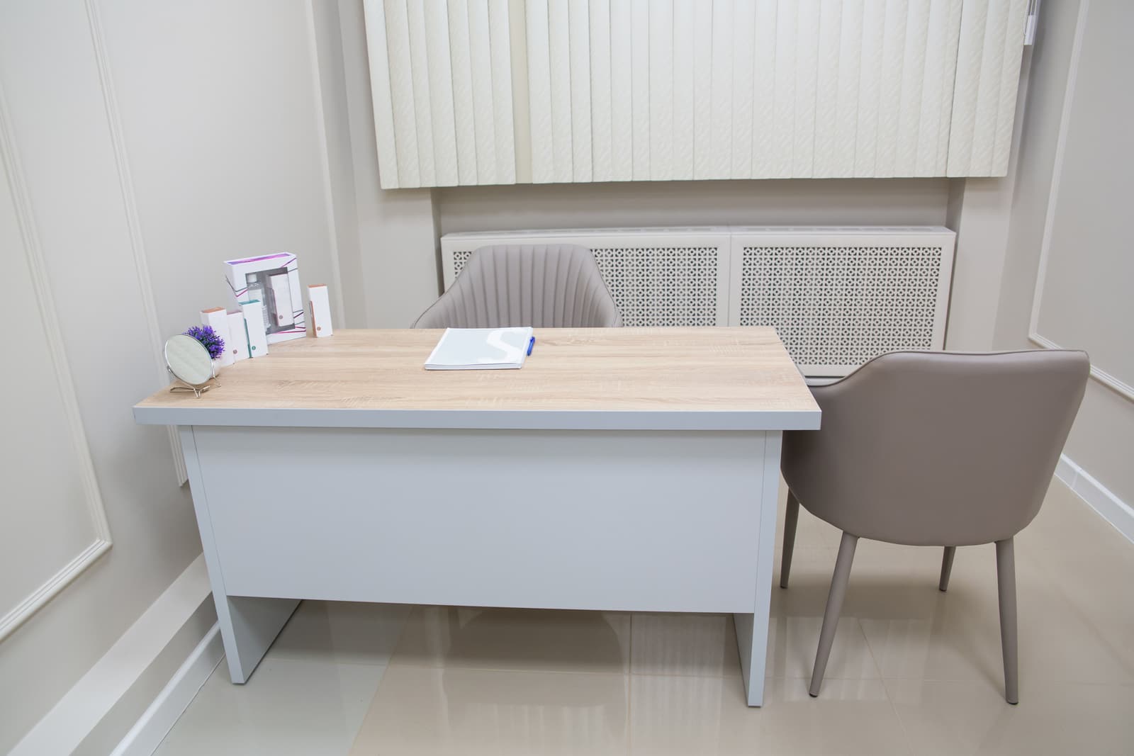 A consulting room at Fieldgate, with an oak-topped desk and a chair on each side.