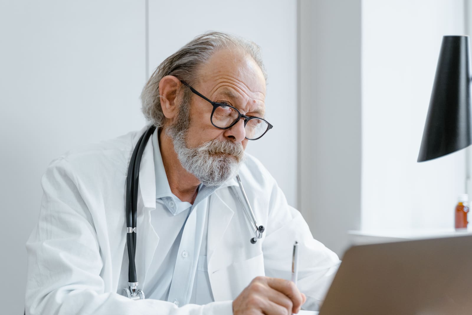 A clinician at his desk during a virtual appointment.