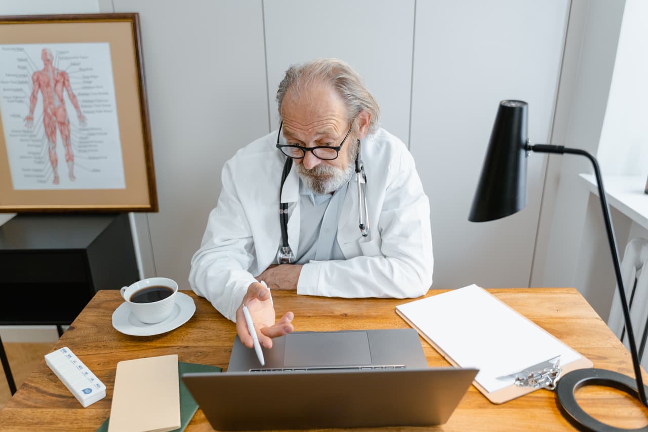 A GP at his desk during a general practice appointment.