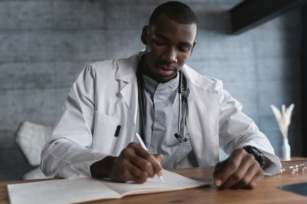 A clinician writing up notes during a longer men's health appointment.