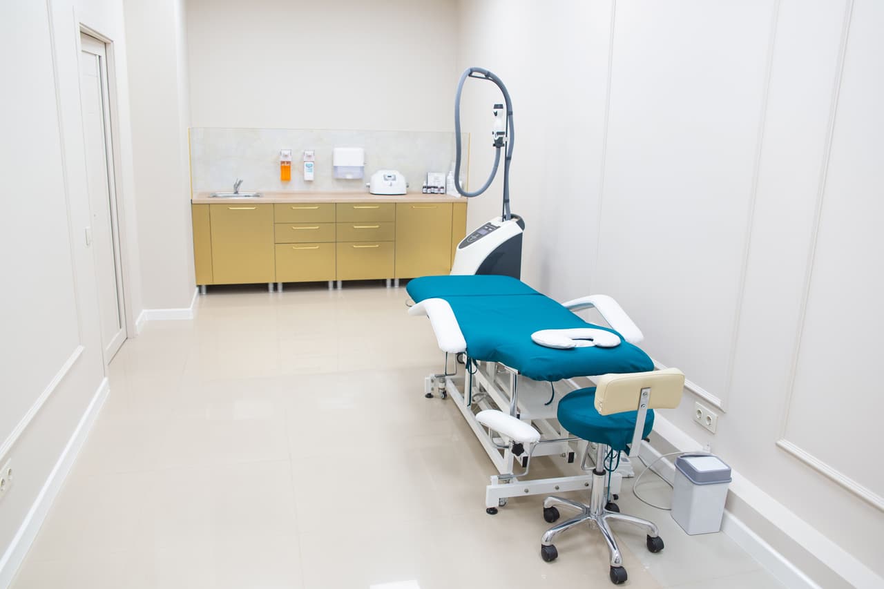 A procedures room with an adjustable couch and an instrument cabinet.