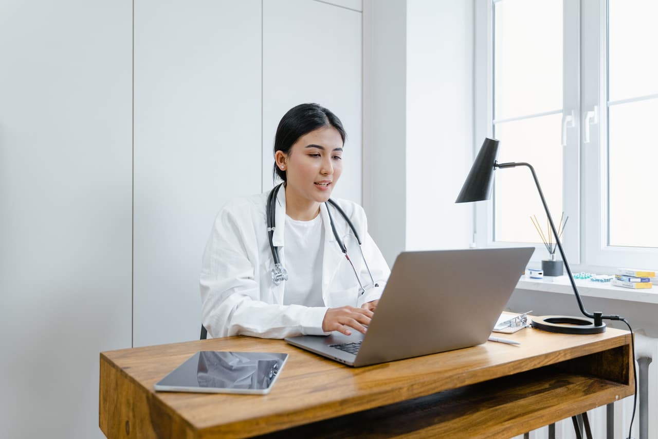 A clinician holding a video appointment from her consulting room.